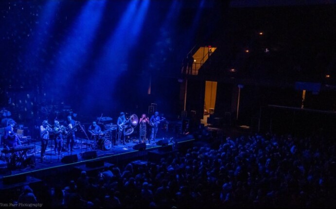 Empire Strikes Brass performing before a large crowd at the Asheville Civic Center