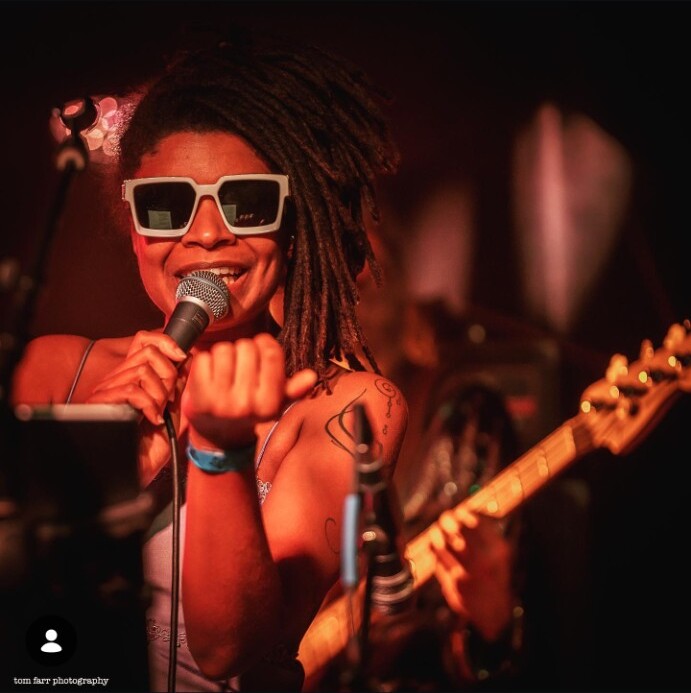 Debrissa singing into a microphone during a live performance