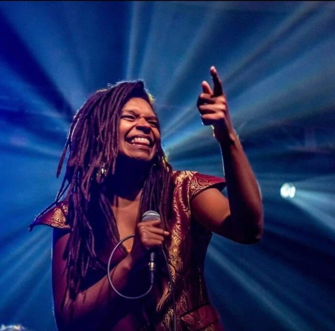 Debrissa smiling onstage beneath blue lights