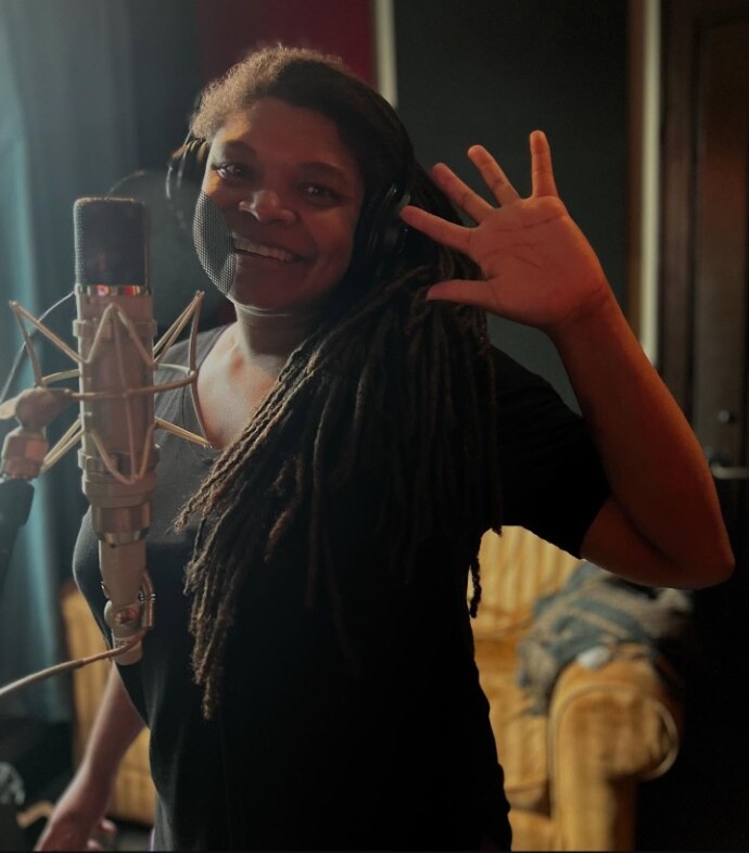Debrissa smiling beside a studio microphone